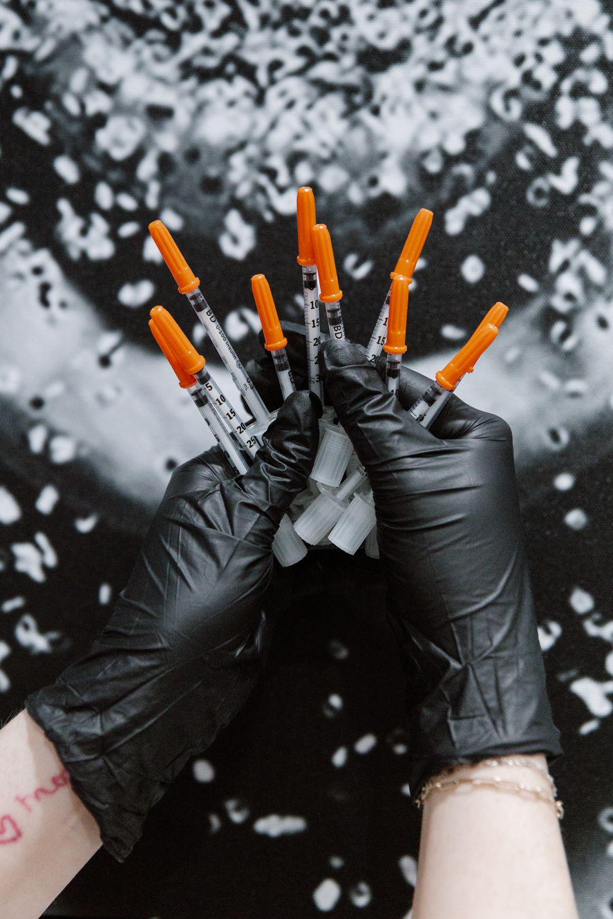 Hands holding needles with caps